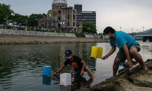 人 floating paper lanterns on the Tenma River in Hiroshima, Japan.